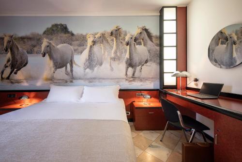 ein Schlafzimmer mit einem Bett und einem Pferdegemälde in der Unterkunft Hotel Granduca SPA & Parking in Grosseto