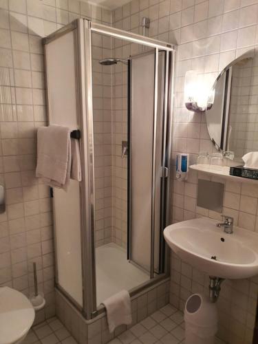 ein Bad mit einer Dusche und einem Waschbecken in der Unterkunft Hotel Gasthof Sternen in Geisingen