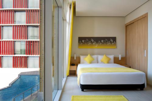 a bedroom with a bed and a swimming pool at Adagio Doha in Doha