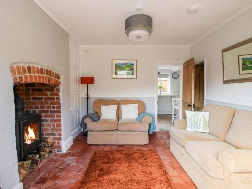 a living room with two couches and a fireplace at The Ferns in Ludlow