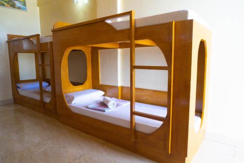 two bunk beds in a room with white sheets at GingGing Hotel And Resort in Oslob