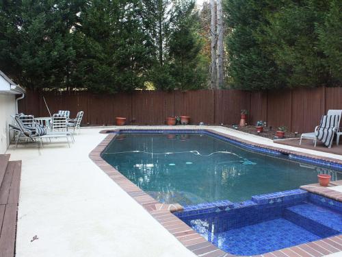 una piscina in un cortile accanto a una recinzione di legno di Angel Cove Family Vacation House a Cumming