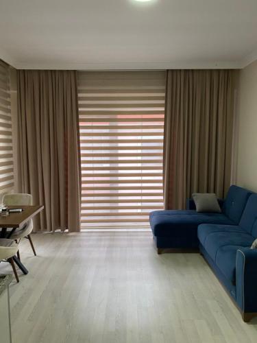 a living room with a blue couch and a table at BALEK APART in Pelitli