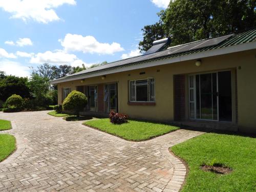 a house with a brick driveway in front of it at 2 bedroomed apartment with en-suite and kitchenette - 2064 in Harare