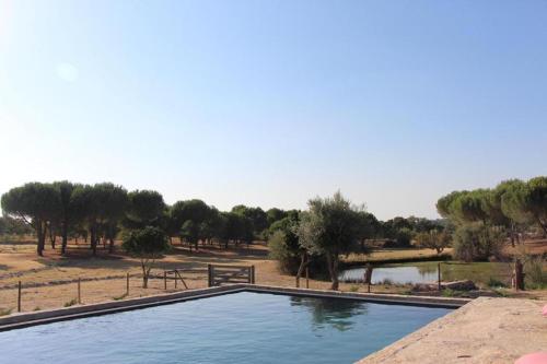 ein großer Pool mit Bäumen im Hintergrund in der Unterkunft Kochab Crato Alentejo in Crato
