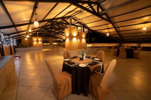 a dining room with a table and chairs and lights at The Terrace by Ladder Mgd by Citrine in Trivandrum
