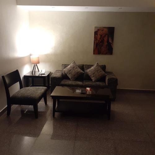 a living room with a couch and a chair at Tamrah Suites Hotel in Amman