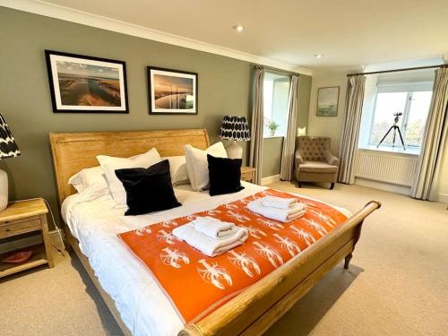 a bedroom with a large bed with towels on it at NEW! Blakeney. Harbour View in Blakeney