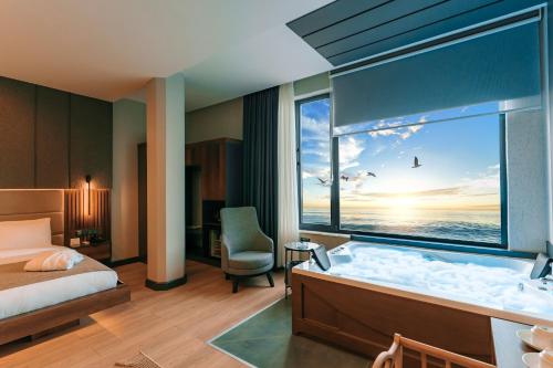 トラブゾンにあるAksular Hotelの海の景色を望むベッドルーム1室(バスタブ付)