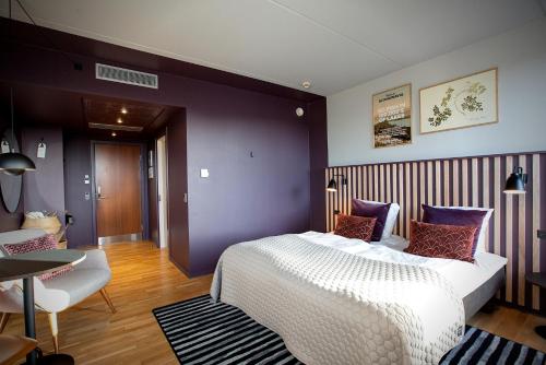 a bedroom with a white bed and purple walls at Hotel Britannia in Esbjerg