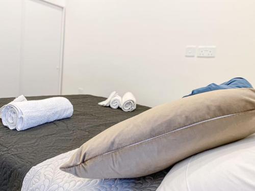 マルサスカーラにあるSea front 3rd floor Apartment in Marsaskala by Soleaのベッド1台(枕、スリッパ2枚付)