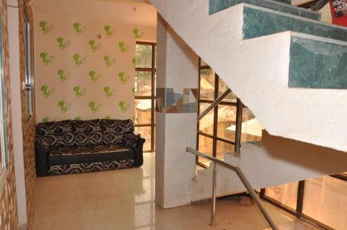 a staircase in a house with a couch in a room at Sky Cottage Matheran in Matheran