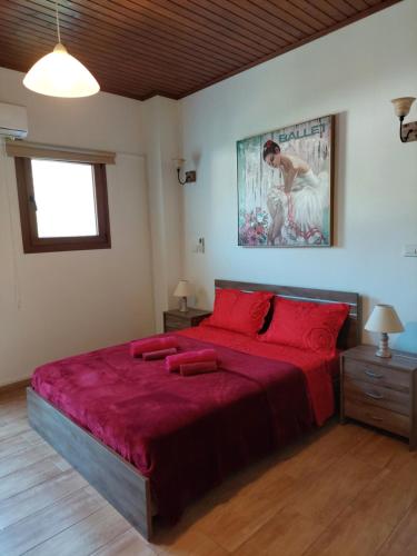 una camera da letto con un grande letto con lenzuola rosse di Love Holiday Suite 2 a Tris Elies