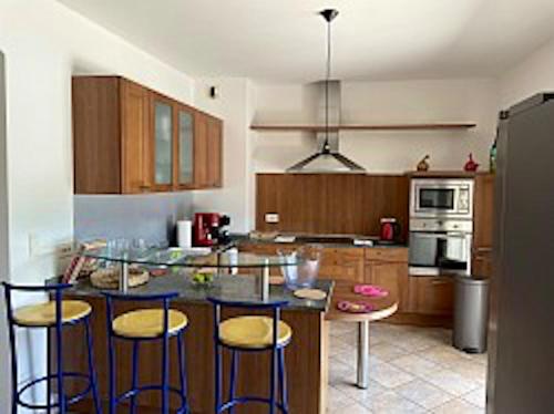 a kitchen with a bar with stools and a counter top at Villa de 4 chambres avec piscine privee jardin clos et wifi a Borgo in Borgo