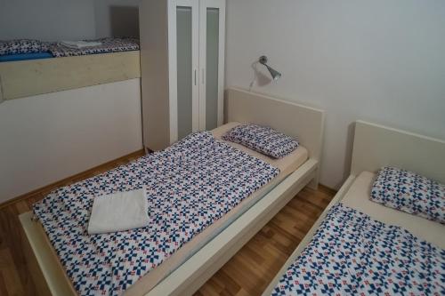 a small bedroom with two beds with blue and white sheets at Apartments Lavric in Nova Vas