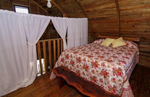 a bedroom with a bed in a wooden cabin at Pilgrims Paradise Cabin 2 in San Ignacio