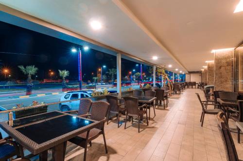 a restaurant with tables and chairs and a view of the street at Aksular Hotel in Trabzon