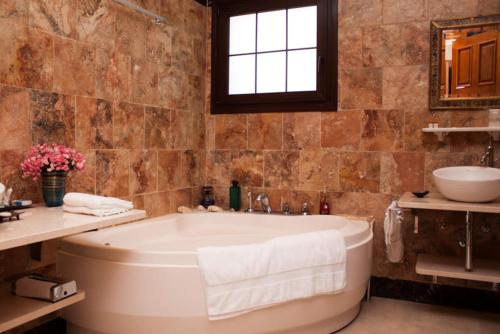 baño con bañera grande y lavamanos en Hotel Villarocamar, en Mijas