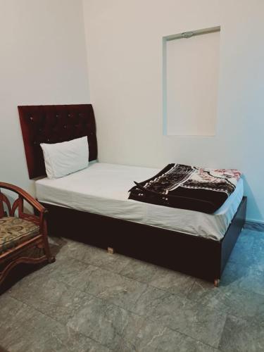Cama en habitación con almohada en Lords Hotel en Lahore