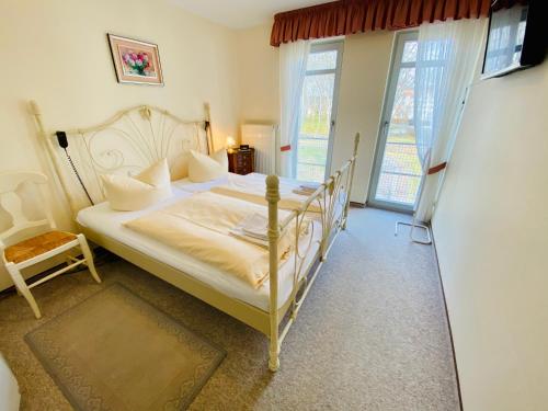 ein Schlafzimmer mit einem weißen Bett und einem Fenster in der Unterkunft Residenz Bleichröder - Ferienwohnung 15 in Heringsdorf