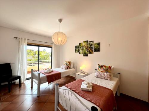a hotel room with two beds and a window at Albufeira Experience With Pool by Homing in Albufeira
