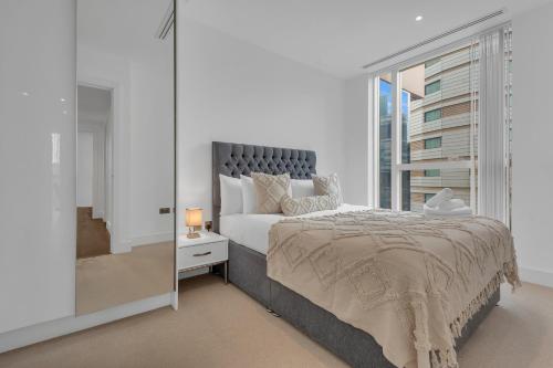 a bedroom with a large bed and a large window at Modern 01 & 02 Bed Apartment in Canary Wharf in London