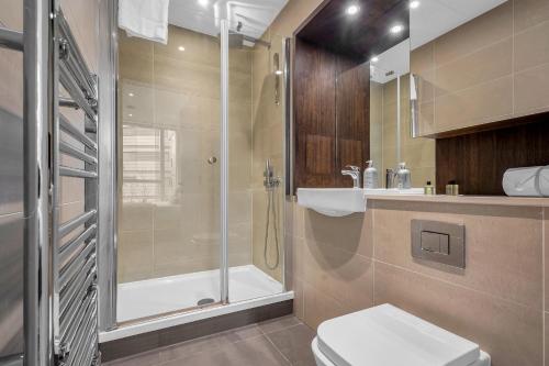 a bathroom with a shower and a toilet and a sink at Modern 01 & 02 Bed Apartment in Canary Wharf in London