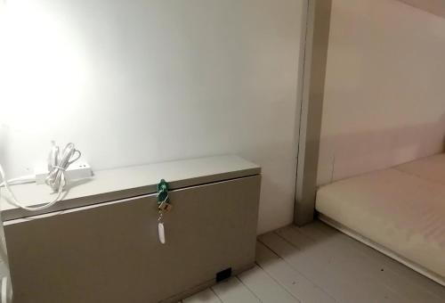 a small green bird sitting on a drawer in a room at Ten to Sen Guesthouse in Takamatsu