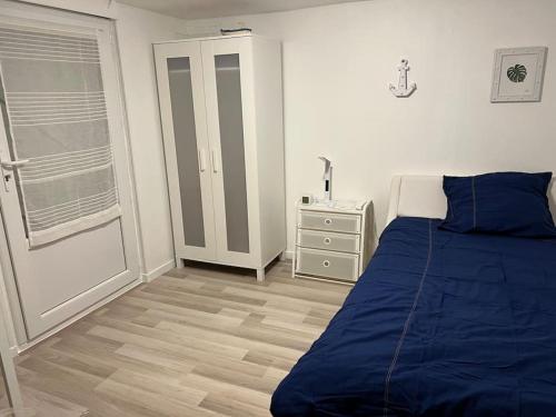 a bedroom with a blue bed and a night stand at Maison indépendante avec 6 chambres proche du tram A in Lormont