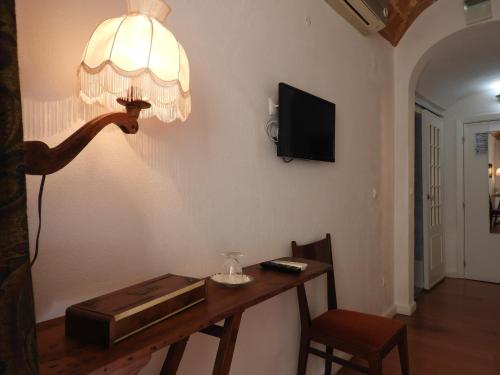 una habitación con una mesa y una lámpara en la pared en Alandroal Guest House, Hotel, en Alandroal
