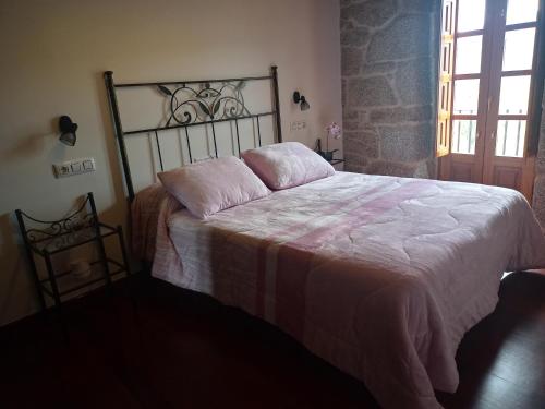 Vivienda Turísitica A Petada de San Clodio في Gomariz: غرفة نوم بسرير كبير مع بطانية بيضاء