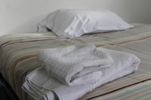 una pila de toallas sentadas encima de una cama en Hôtel et Restaurant de la Gare Torigny-les-Villes, en Torigni-sur-Vire