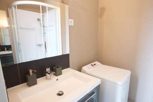 uma casa de banho com um lavatório, um WC e um espelho. em Hossegor - Plage 100m - Surf - Famille - Couple em Soorts-Hossegor