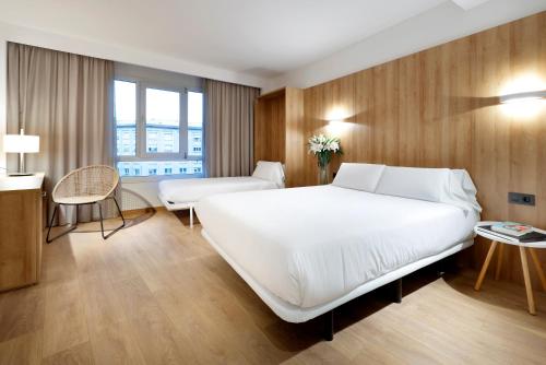 - une chambre avec un grand lit blanc et un bureau dans l'établissement Apartaments SB Corona Tortosa, à Tortosa