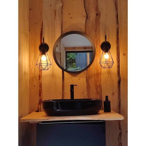 a bathroom with a black sink and a mirror at Shambhala centrum in Lúčka