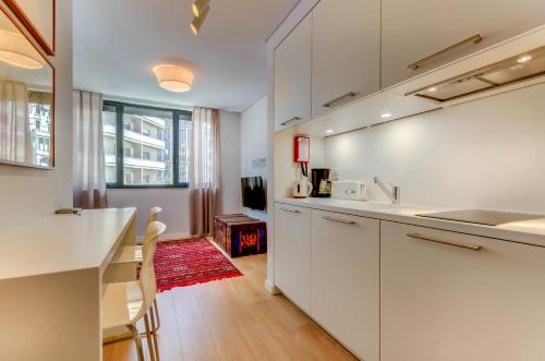 a kitchen with white cabinets and a counter top at LSA Liberdade by Numa in Lisbon