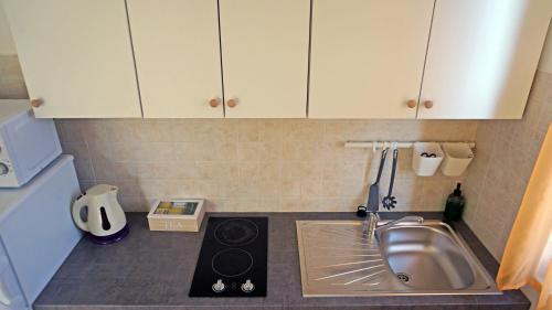 a small kitchen with a sink and a stove at Studio Apartment Michelle - Intermezzo with sea view in Rabac