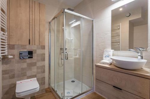 a bathroom with a glass shower and a sink at Green Park Resort C9-z dostępem do basenu, sauny, jacuzzi, siłowni in Szklarska Poręba