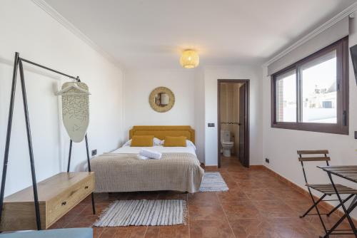 een slaapkamer met een bed, een tafel en een raam bij Urbe10 Pedregalejo Loft 3 in Málaga