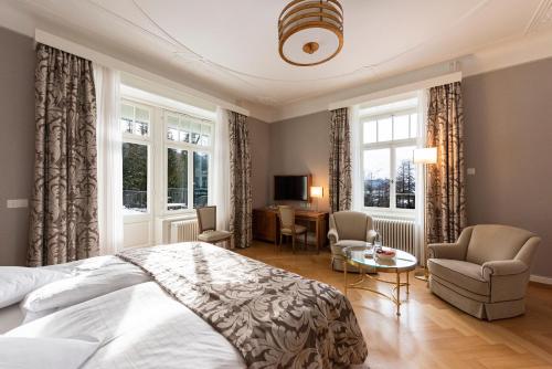 - une chambre avec un lit, deux chaises et une table dans l'établissement Hotel Waldhaus Sils, à Sils-Maria