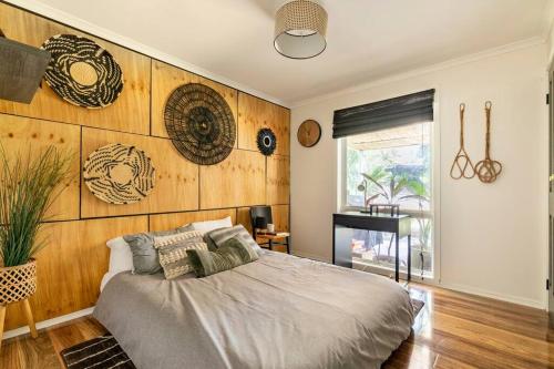 a bedroom with a bed and a wooden wall at The Tranquil Traveller in Sunbury