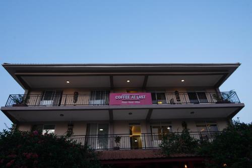 a building with a pink sign on the balcony at Olori Flats in Munyonyo