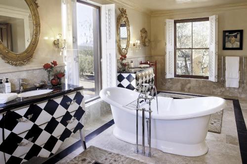 a bathroom with a large tub and two sinks at La Residence in Franschhoek