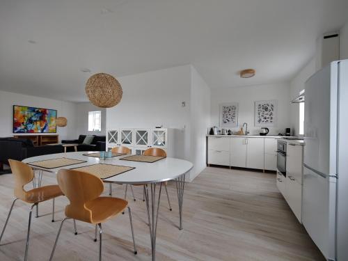 a kitchen and living room with a table and chairs at GIMLEretreat in Marielyst