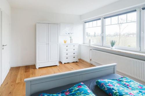 Ferienwohnung Stylo 2.0 في سيل: غرفة نوم مع خزانة بيضاء ونافذة