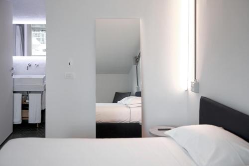 a bedroom with a bed and a sink and a mirror at BasicVillage Milano in Milan