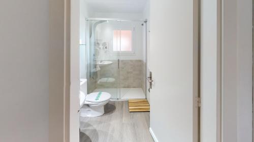 a bathroom with a toilet and a glass shower at Hotel Bella Dolores in Lloret de Mar