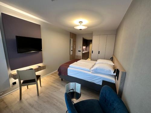 a hotel room with a bed and a couch and a tv at Apartment-Hotel Hamburg Mitte in Hamburg