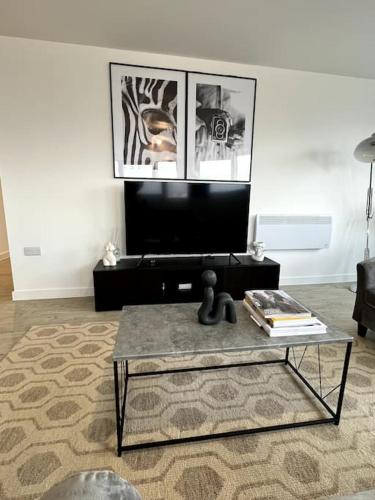 a living room with a coffee table and a tv at Luxurious City View Apartment in Salford in Manchester