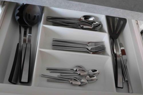 a drawer filled with silver utensils in a kitchen at Luxurious City View Apartment in Salford in Manchester